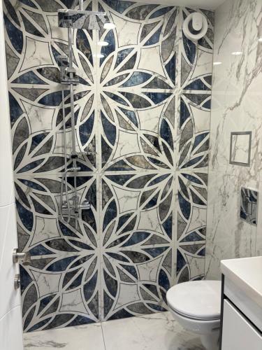 baño con aseo y pared de azulejos en Sofia Apartment, en Sofía