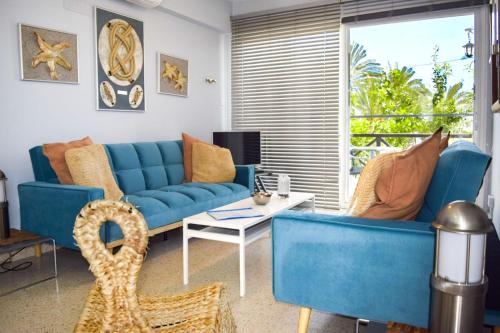 a living room with a blue couch and a table at Yiallos Village C107 in Larnaca