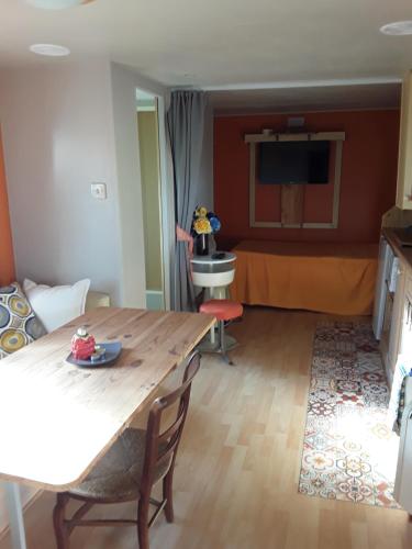 a living room with a table and a bed at Location en Pré montagne pyrénéenne in Saleich