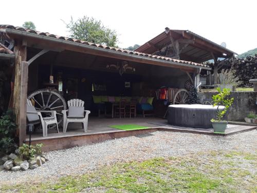 une terrasse avec une table et des chaises dans une maison dans l'établissement Location en Pré montagne pyrénéenne, à Saleich