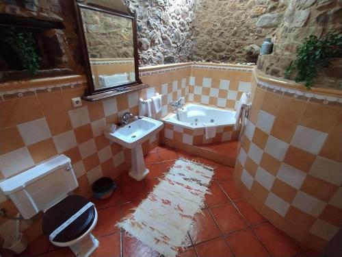 een badkamer met een wastafel, een toilet en een bad bij Río da Cruz in Cariño