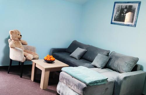 a living room with a couch and a teddy bear at Vila Dvor SUBOTICA in Subotica