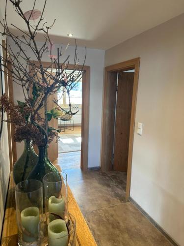 a room with a table with a vase and a plant at Haus Egger in Jochberg