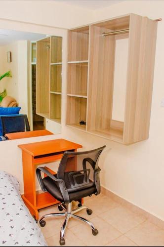 ein Büro mit einem Schreibtisch und einem Stuhl in einem Zimmer in der Unterkunft Amani stays Embu-white in Embu