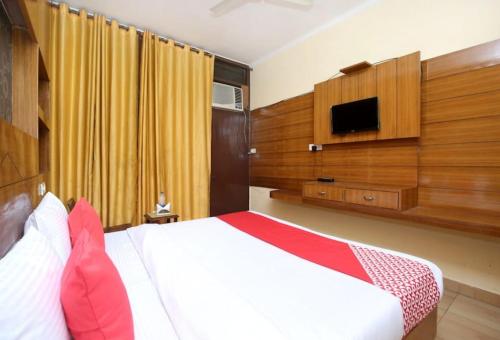Schlafzimmer mit einem Bett und einem Flachbild-TV in der Unterkunft Hotel Skyfox in Mohali