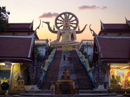 a large buddha statue on the stairs of a building at Explorar Koh Samui - Adults Only Resort and Spa in Mae Nam