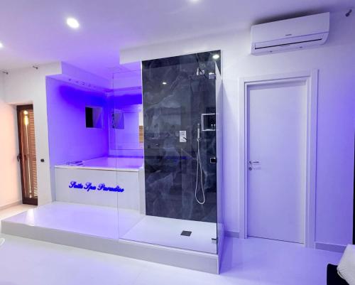 a bathroom with a shower with purple lighting at Hotel Paradiso in Lago Patria