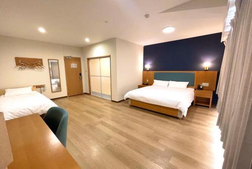 Cette chambre comprend 2 lits et une table. dans l'établissement Fujinomori Hotel, à Fujikawaguchiko