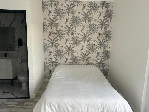 a bedroom with a bed and a wallpaper with palm trees at Hôtel de La gare-Les Floralies in Poitiers