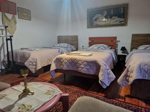 a bedroom with two beds and a table with at Hostel-F in Gjakove