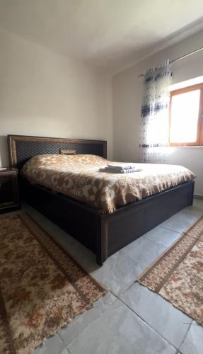 - une chambre avec un grand lit dans l'établissement Strofka Guest House, à Maliq