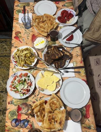 une table avec de nombreuses assiettes de nourriture dans l'établissement Strofka Guest House, à Maliq