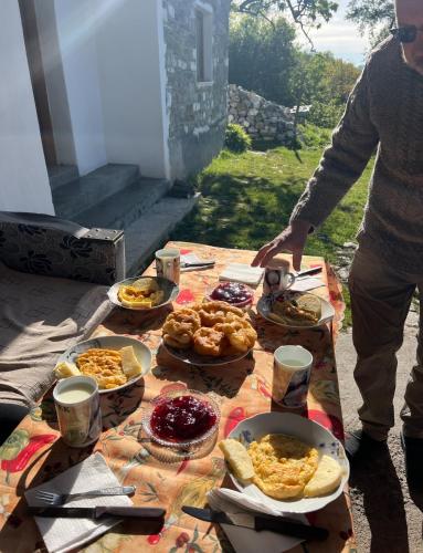 une table remplie de nourriture au-dessus d'une table dans l'établissement Strofka Guest House, à Maliq