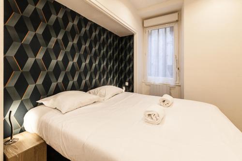 a bedroom with a large bed with two towels on it at Ty Gwened - Centre Historique - Calme - Wifi in Vannes