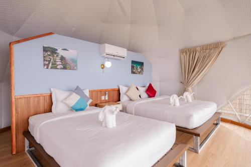2 Betten in einem Zimmer mit weißer Bettwäsche in der Unterkunft Romhaey Kirirom Resort in Kampong Seila