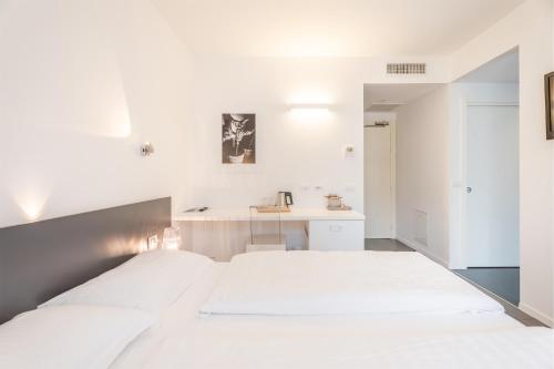 a white bedroom with a large bed and a sink at On The Rock in Arco