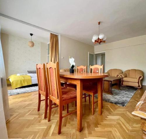 ein Esszimmer mit einem Tisch und Stühlen sowie ein Schlafzimmer in der Unterkunft Pipacs Apartman in Szeged