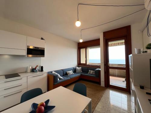 uma cozinha e sala de estar com um sofá e uma mesa em Nereidi 307 em Sanremo
