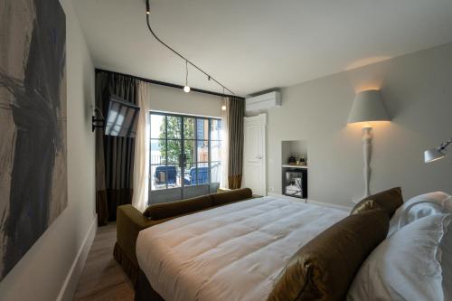 een slaapkamer met een groot bed en een raam bij Hotel Arancioamaro in Cannero Riviera