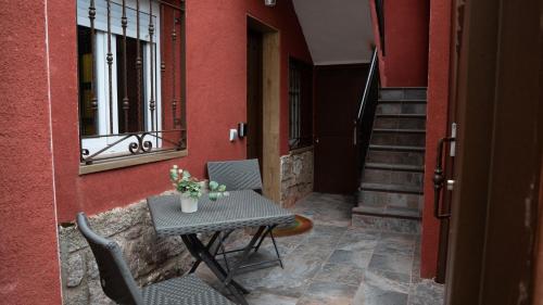 einen Tisch und Stühle auf einer Veranda mit einem Tisch und einem Fenster in der Unterkunft APARTAMENTOS PRADERAS PANTANO SAN JUAN in Pelayos de la Presa