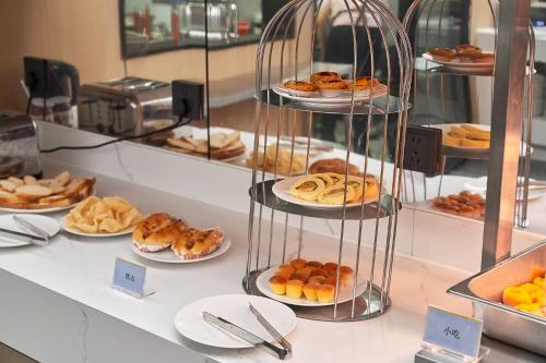 a display case with different types of pastries on plates at 珠海海之珠丨Global Romantic Pearl酒店-拱北口岸珠海站店 in Zhuhai