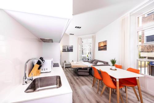 uma cozinha e sala de estar com mesa e cadeiras em Apartamentos Turísticos Gran Vía em Cartagena
