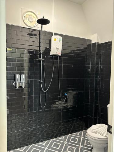 eine Dusche im Bad mit schwarzer Fliesenwand in der Unterkunft 385 Lake 