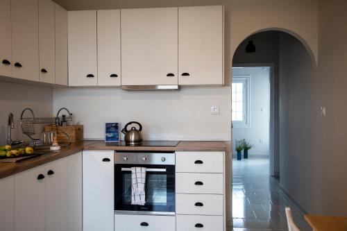a kitchen with white cabinets and a tea kettle on the stove at Naja's Studio in Souvala