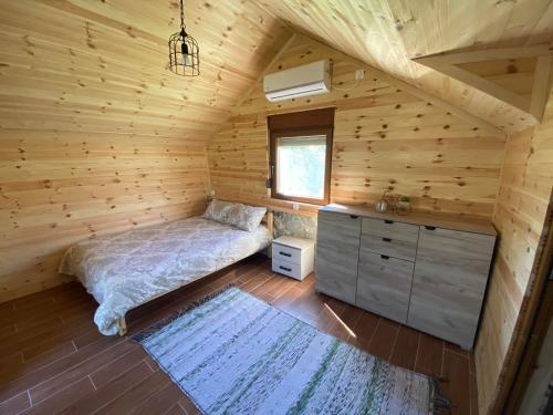 a bedroom with a bed in a wooden cabin at Ethno House Bektesevic in Gusinje