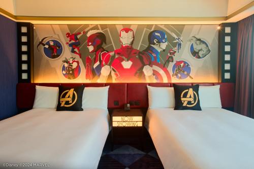 2 letti in una camera con un dipinto sul muro di Disney's Hollywood Hotel a Hong Kong