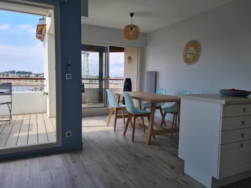 une cuisine et une salle à manger avec une table et des chaises dans l'établissement REF 048 - Appartement entièrement rénové pour six personnes vue mer et port Crouesty ARZON, à Arzon