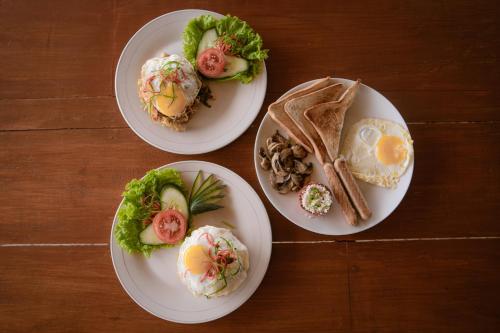 three plates of food on a wooden table at The Green Ponci Bedugul in Baturiti