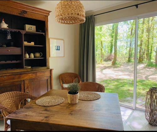 - une salle à manger avec une table et des chaises en bois dans l'établissement Le Buscagneau, à Béraut
