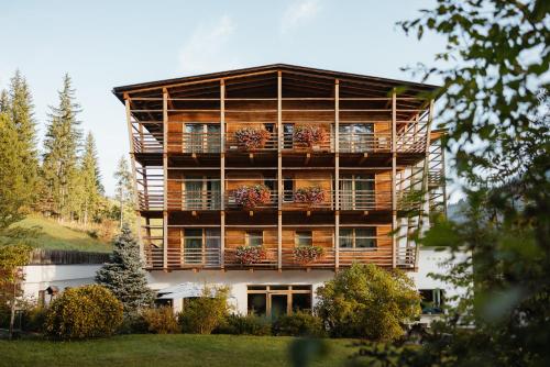a large building with balconies and flowers on it at Hotel Melodia del Bosco in Badia
