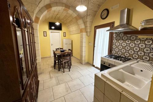 una cucina con tavolo e una cucina con pareti gialle di Casa Begi a Guagnano