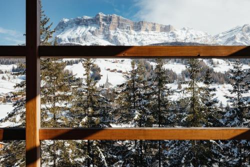 a window with a view of a snowy mountain at Hotel Melodia del Bosco in Badia