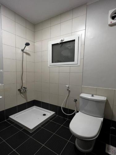 een badkamer met een toilet en een tv aan de muur bij شروق المدينة - مدينة الملك عبدالله الاقتصادية in King Abdullah Economic City