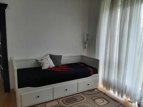 łóżko w pokoju z białymi zasłonami w obiekcie Senvages nuoma w Kłajpedzie