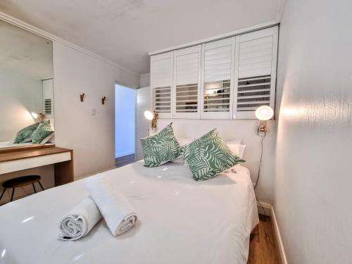 a white bedroom with a bed and a desk at 79 Chaka's Cove in Ballito