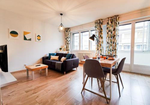 uma sala de estar com uma mesa e um sofá em Le Coqu'Aix - Hyper-Centre - Parking - Wifi - Netflix em Aix-les-Bains
