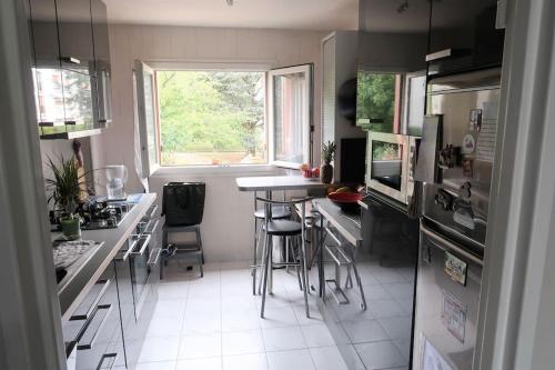 uma cozinha com balcão e bancos em Joli F3 en centre-ville em Chilly-Mazarin