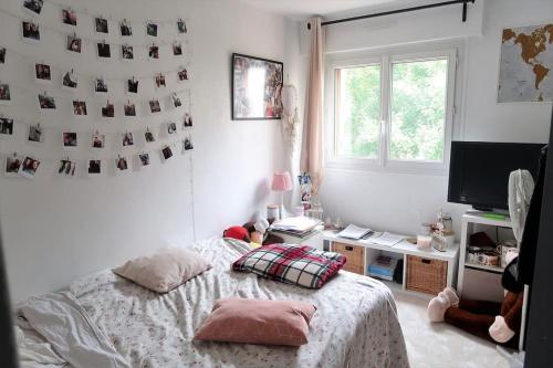 um quarto com uma cama, uma secretária e uma janela em Joli F3 en centre-ville em Chilly-Mazarin