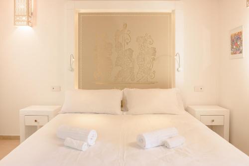 a bedroom with a white bed with two towels on it at La Vinia Bed&Wine Experience - Adults Only in Sassari