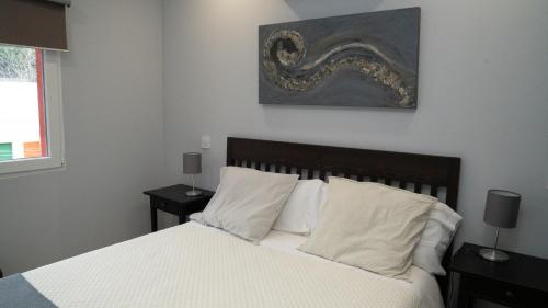 - une chambre avec un lit doté de draps et d'oreillers blancs dans l'établissement APARTAMENTO PRADERAS PANTANO SAN JUAN PRIMERA PLANTA, à Pelayos de la Presa