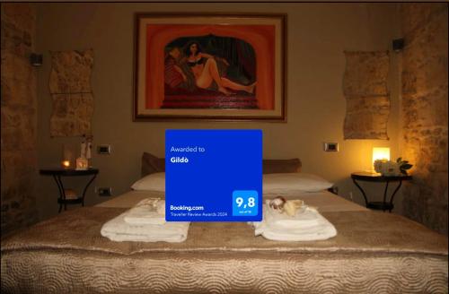 uma placa em cima de uma cama num quarto de hotel em Gildò em Trani