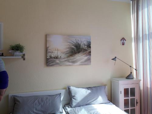a bedroom with a bed and a picture on the wall at Koje "neu" in Burgtiefe auf Fehmarn 