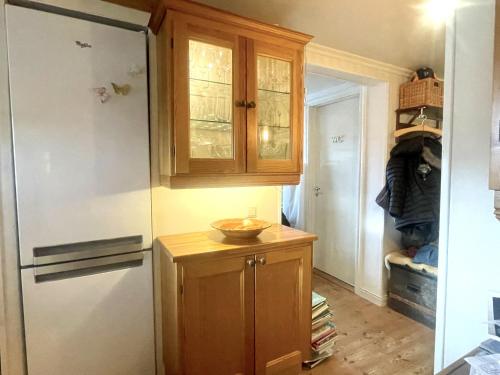 a kitchen with a refrigerator and a wooden cabinet at Pleasant accommodation with its own beach located along the Jungfrukusten in Bergby