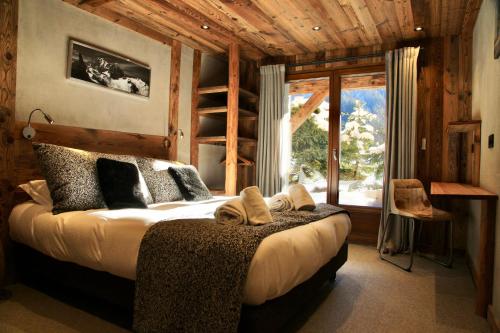 a bedroom with a bed and a large window at Chalets Grands Montets in Chamonix-Mont-Blanc