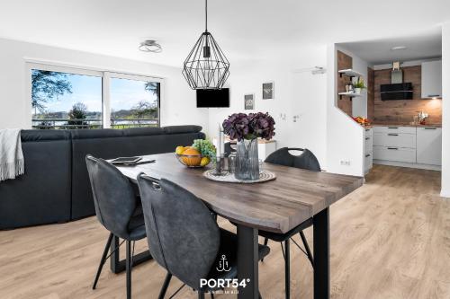 a kitchen and dining room with a wooden table and chairs at Ferienwohnung Winningmay 1 Füsing in Schaalby