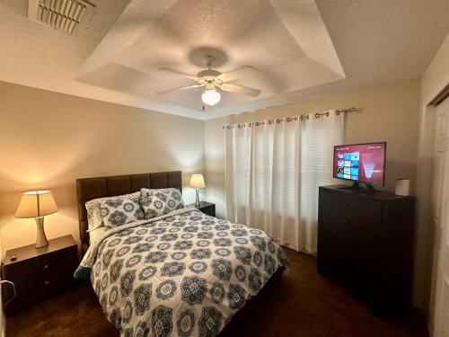 1 dormitorio con 1 cama y TV de pantalla plana en Grand Panoramic 3BR Townhouse near Disney, en Kissimmee